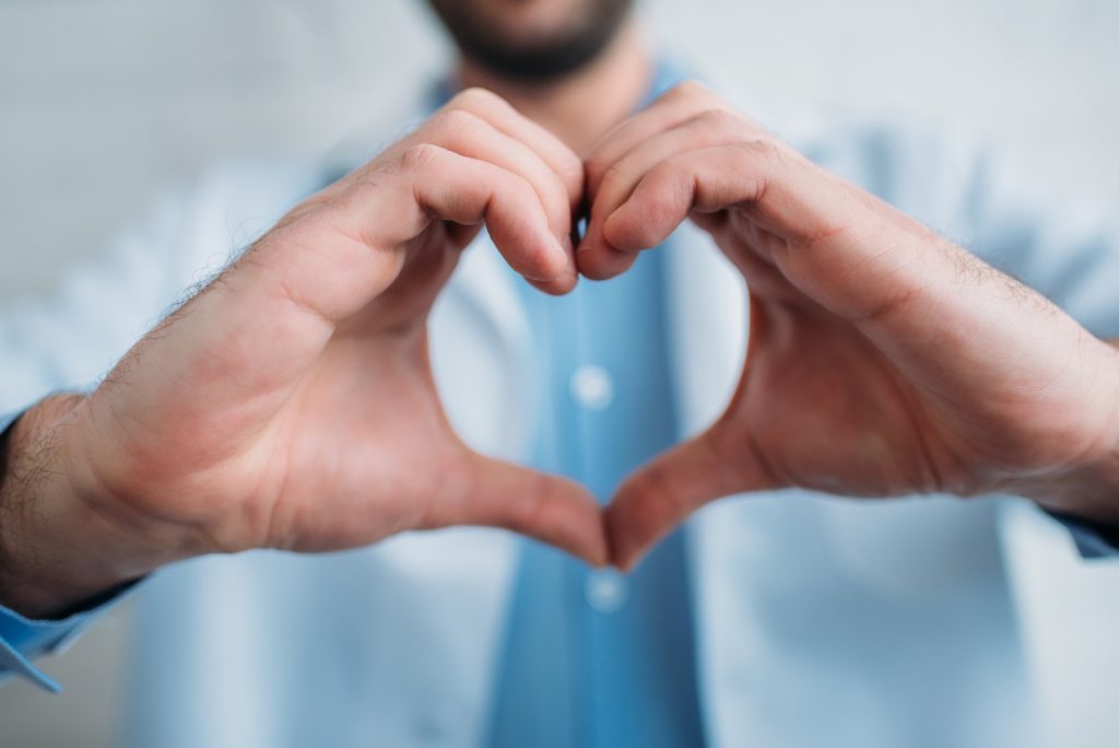 cropped shot of doctor showing heart sign with hands